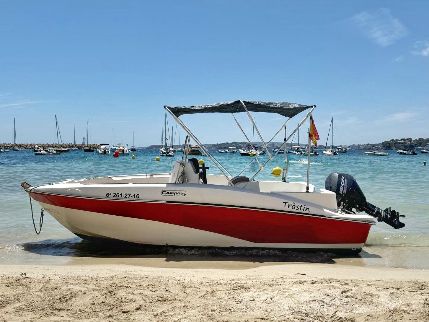Lancha Compass roja y blanca sobre la arena en playa de Palma