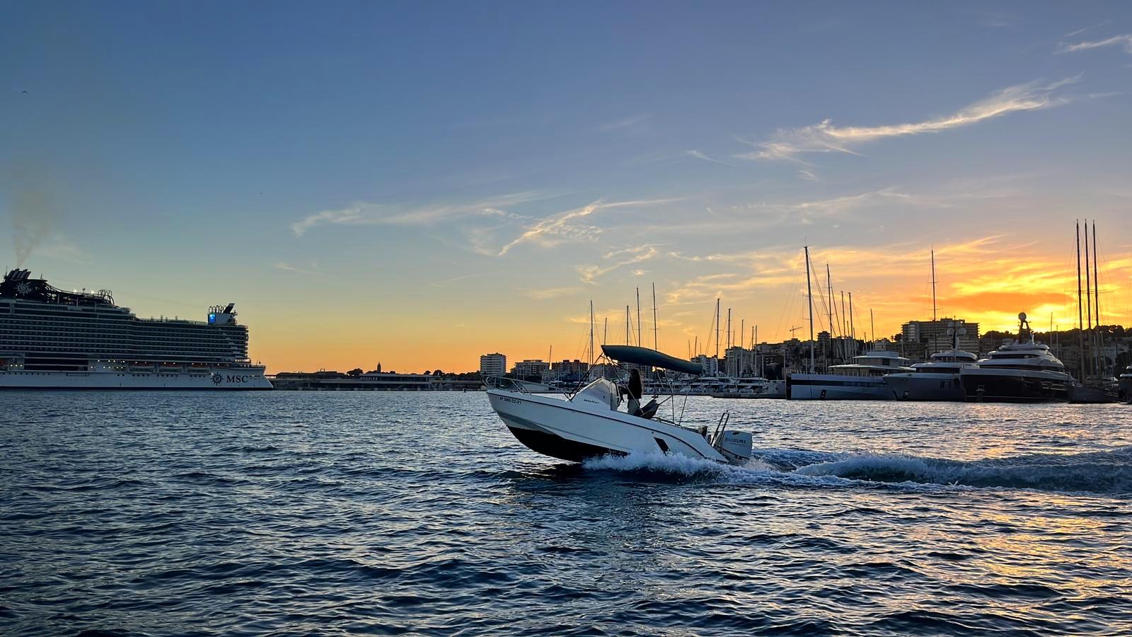 Lancha navegando al atardecer frente al puerto de Palma